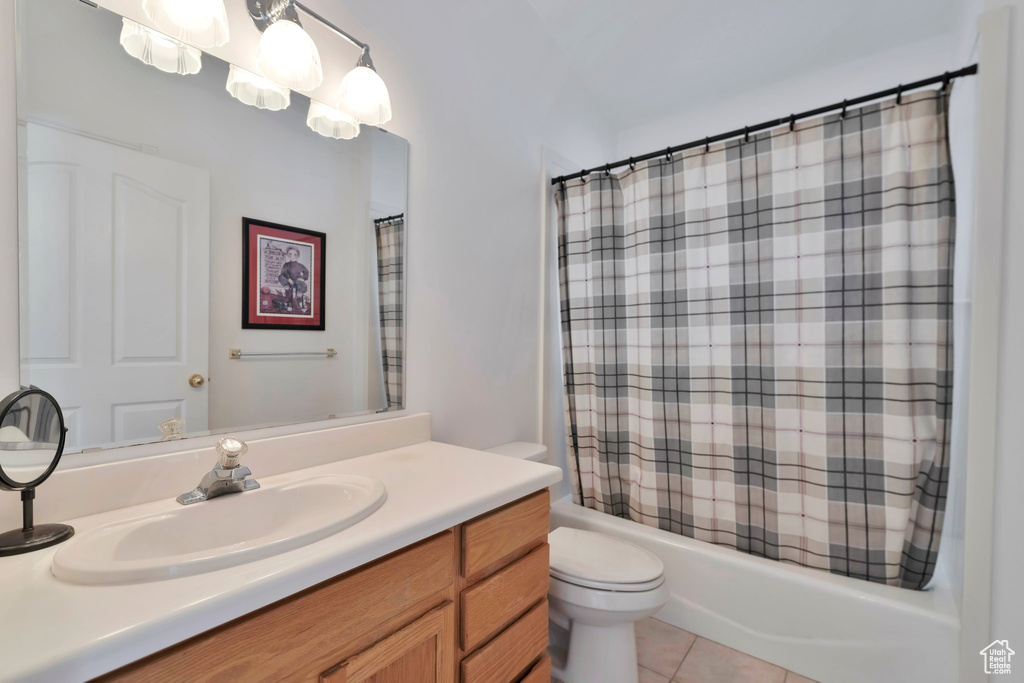 Full bathroom with shower / tub combo, vanity with extensive cabinet space, tile flooring, and toilet
