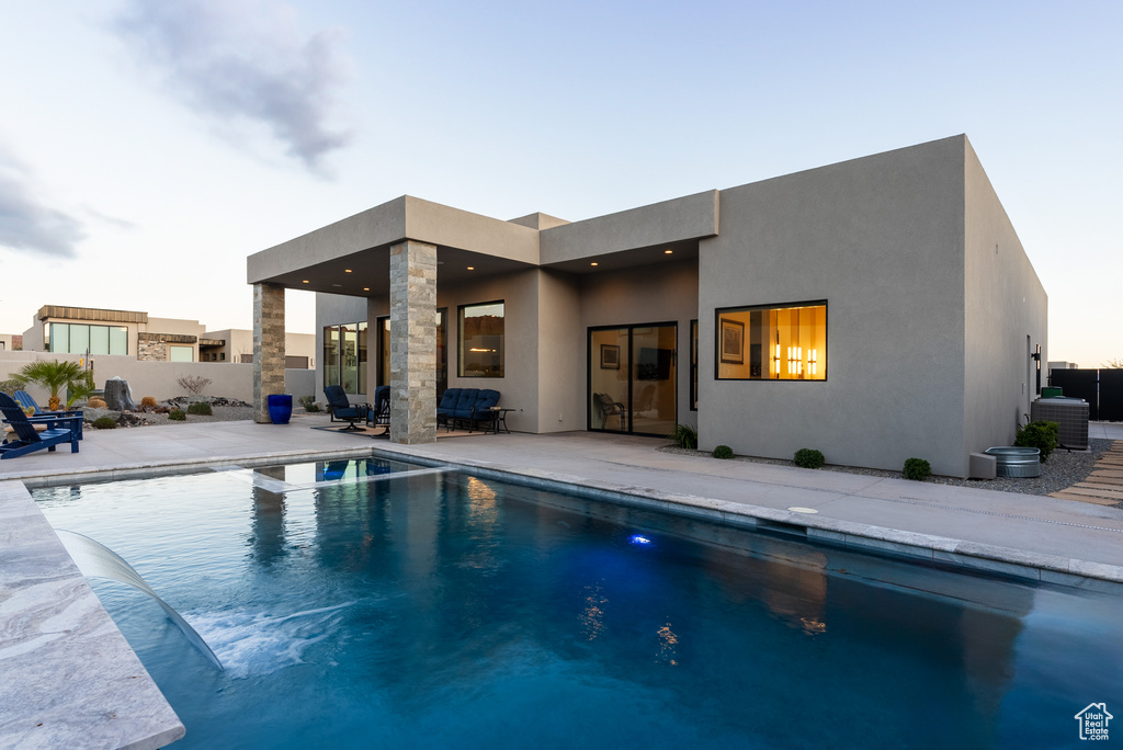 Pool at dusk featuring a patio and central AC