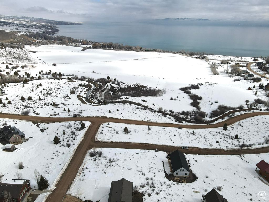 Snowy aerial view with a water view