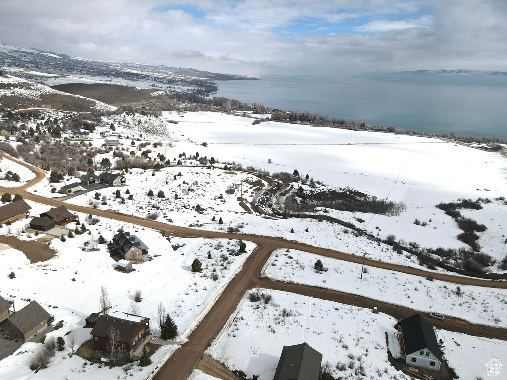 Snowy aerial view featuring a water view