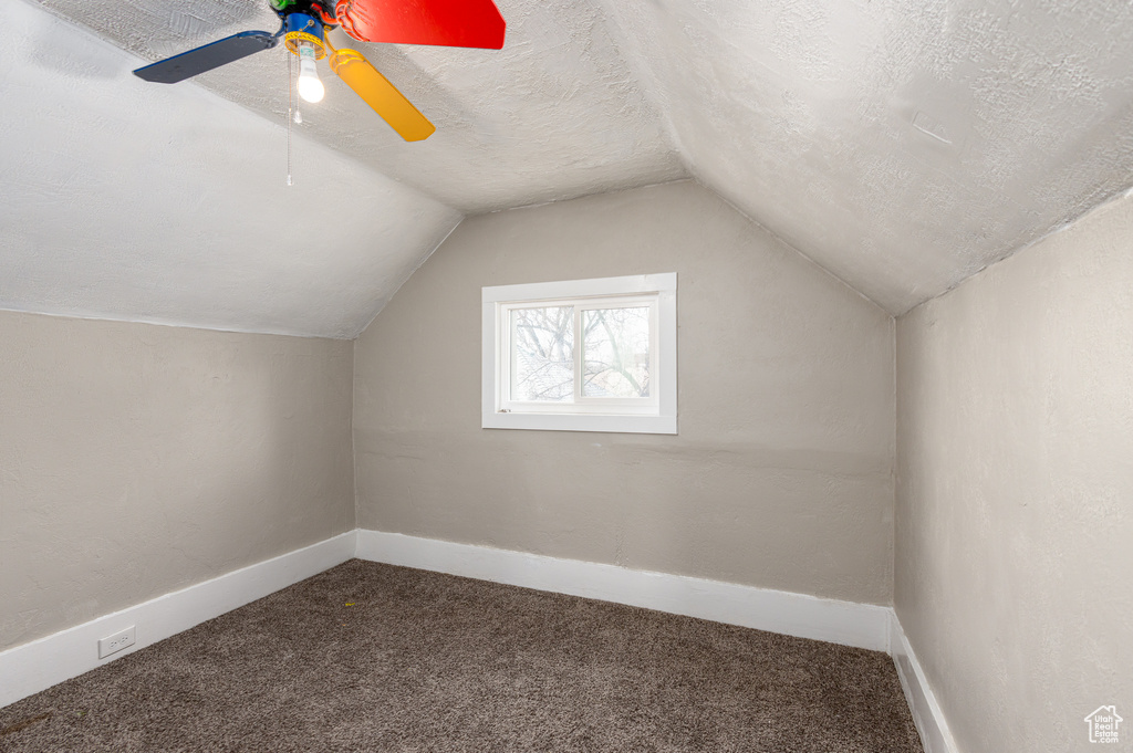 Additional living space featuring ceiling fan, a textured ceiling, lofted ceiling, and carpet