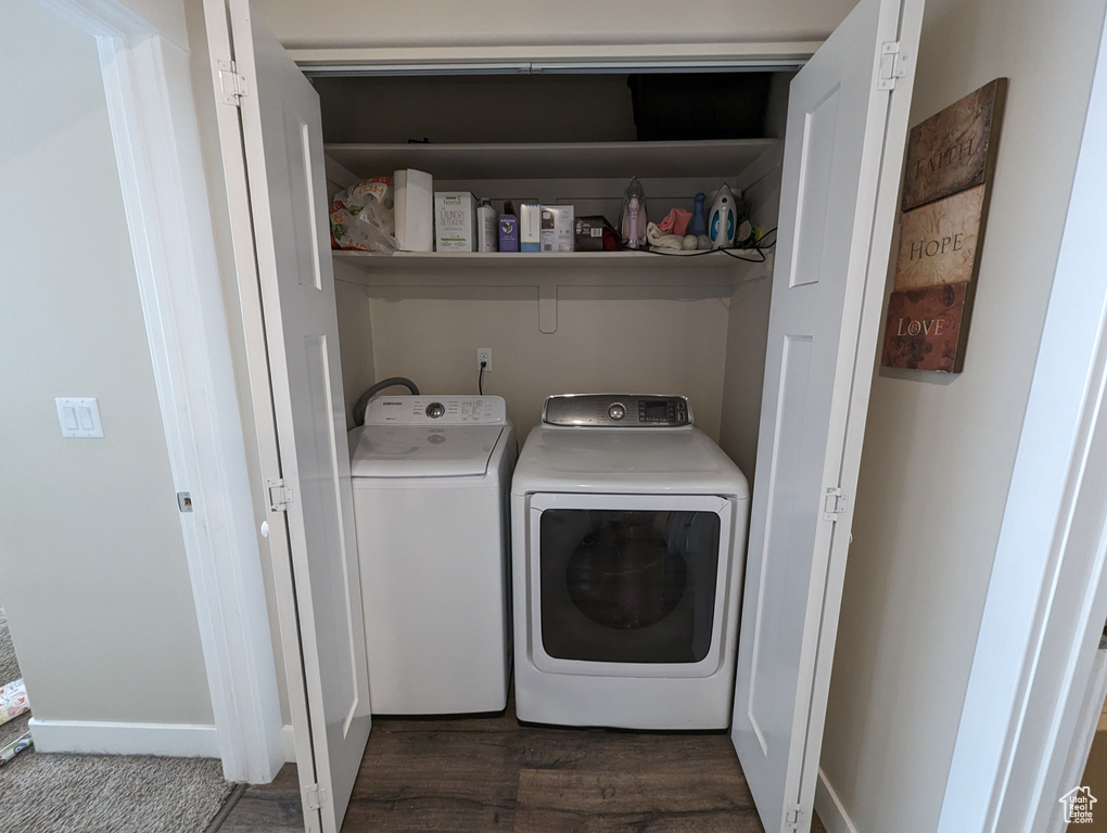 Laundry area with washer and clothes dryer and dark wood-type flooring