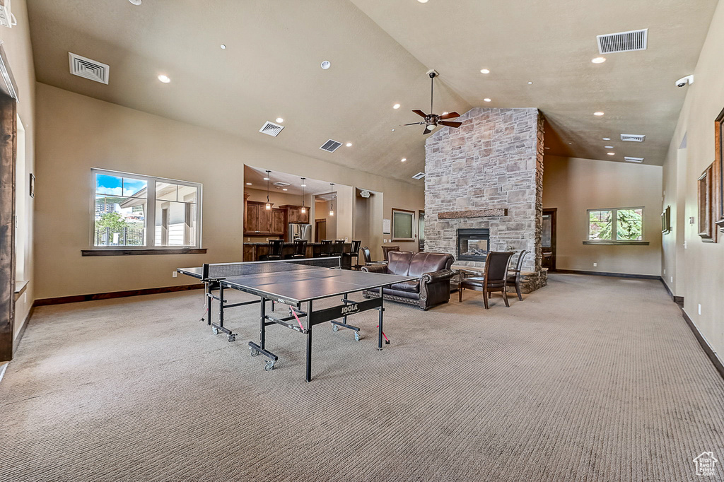 Rec room featuring high vaulted ceiling, a wealth of natural light, ceiling fan, and a fireplace