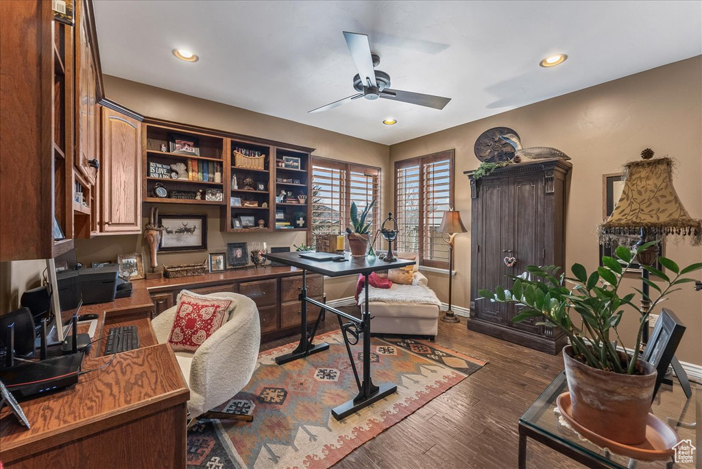 Home office with ceiling fan and dark wood-type flooring