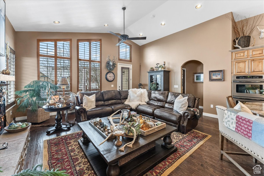 Living room with high vaulted ceiling, dark wood-type flooring, and ceiling fan