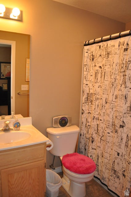 Bathroom featuring tile floors, large vanity, and toilet