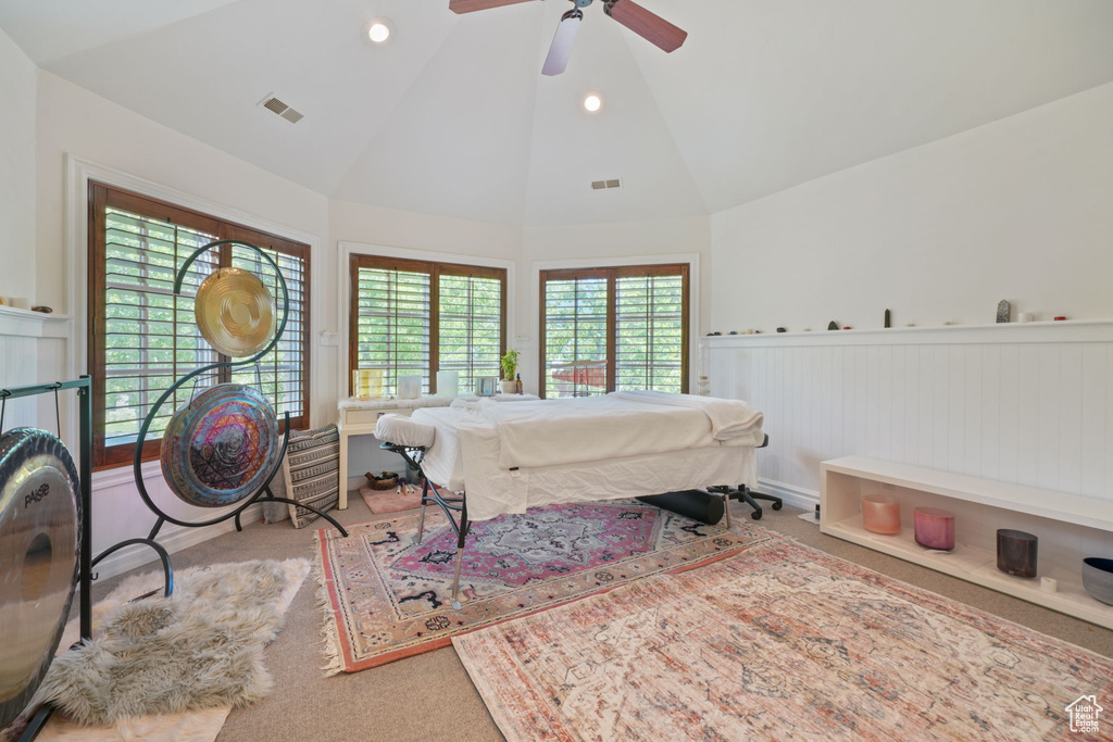 Bedroom with high vaulted ceiling, light carpet, and ceiling fan