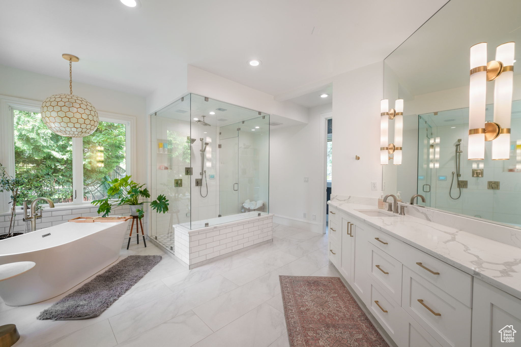 Bathroom featuring tile flooring, vanity, and plus walk in shower