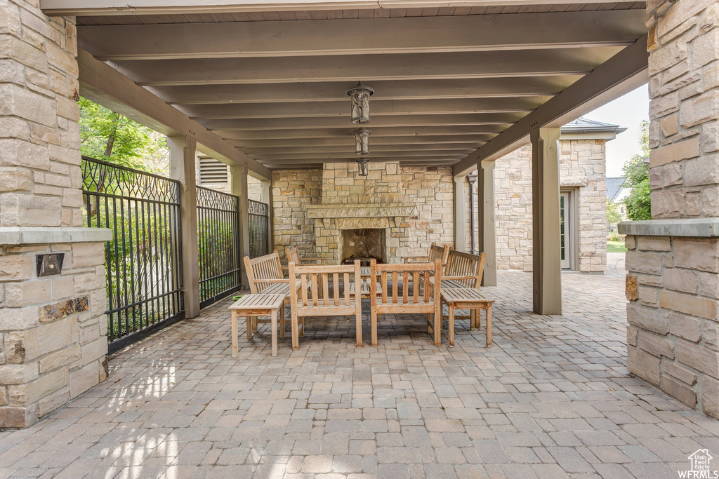 View of patio with an outdoor stone fireplace