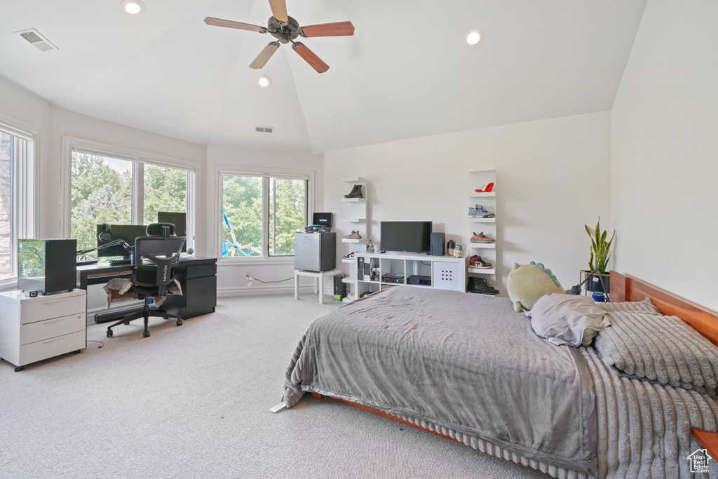 Bedroom with ceiling fan, light carpet, and vaulted ceiling