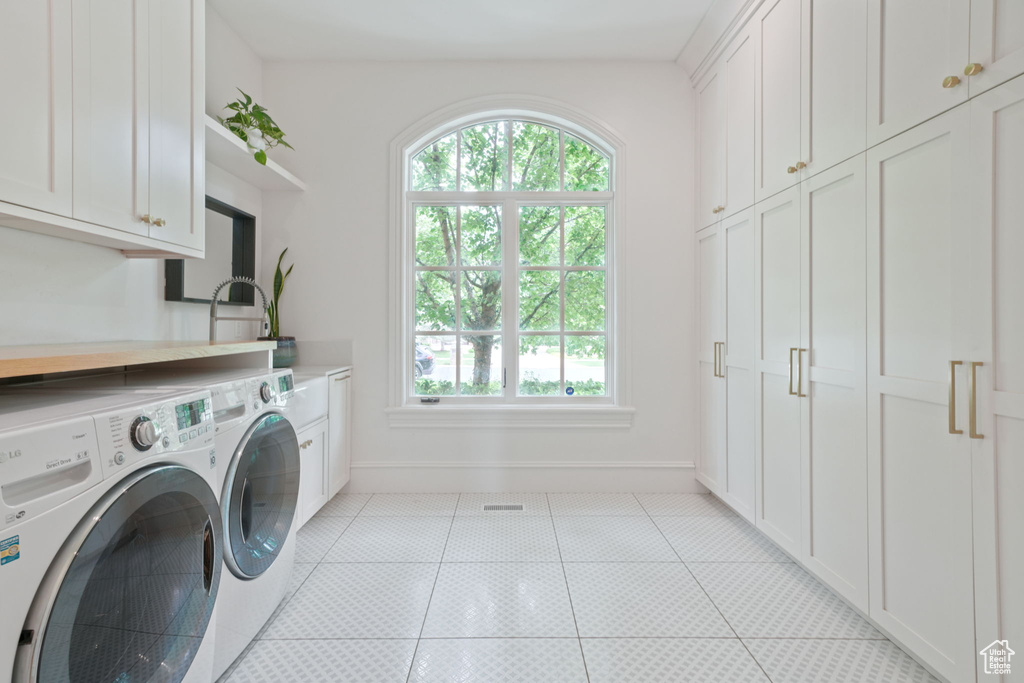Laundry room featuring cabinets, sink, light tile flooring, and washer and dryer