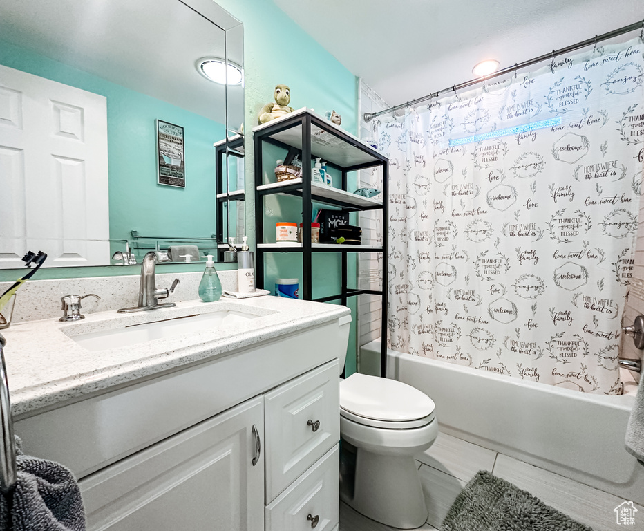 Full bathroom featuring shower / bath combo, tile flooring, vanity, and toilet