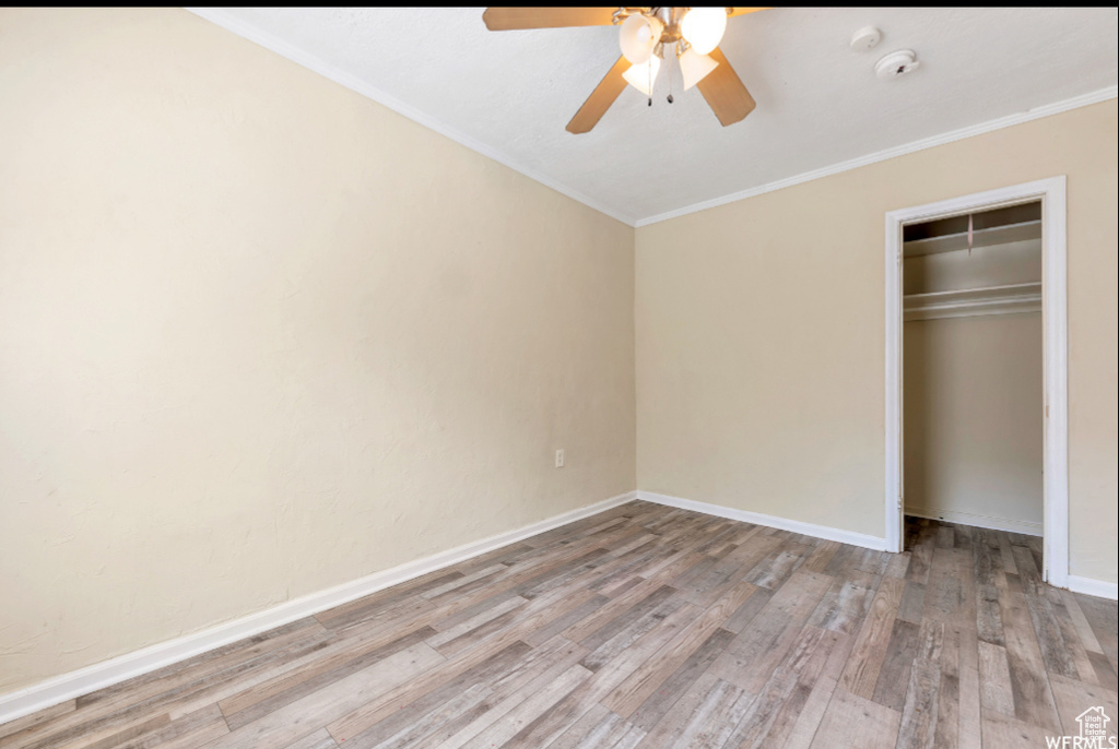 Unfurnished bedroom featuring ornamental molding, a closet, ceiling fan, and light hardwood / wood-style flooring
