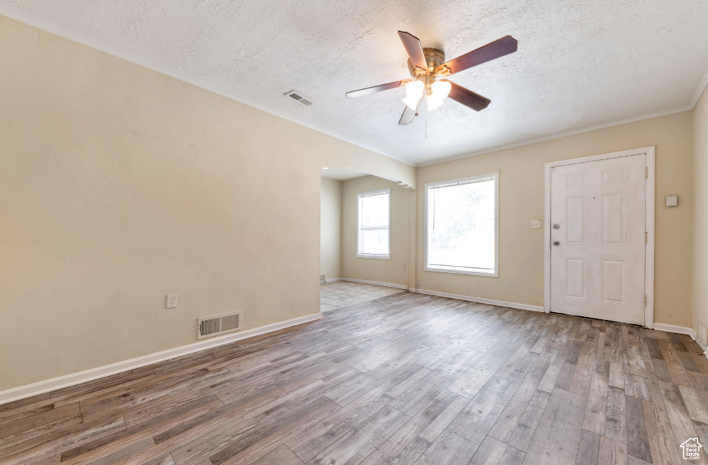 Unfurnished room with a textured ceiling, dark wood-type flooring, and ceiling fan