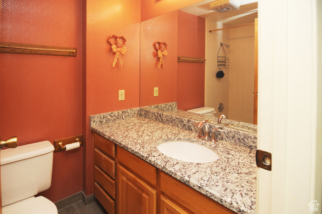 Bathroom featuring vanity with extensive cabinet space, tile flooring, and toilet