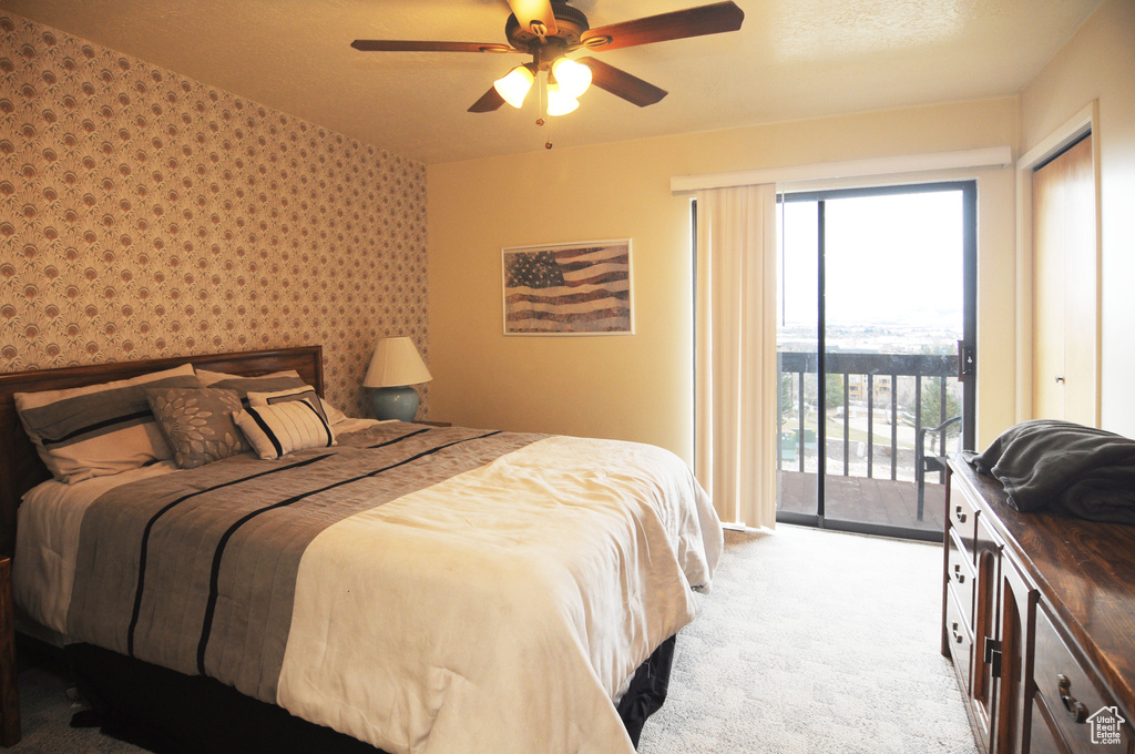 Carpeted bedroom with multiple windows, access to outside, and ceiling fan