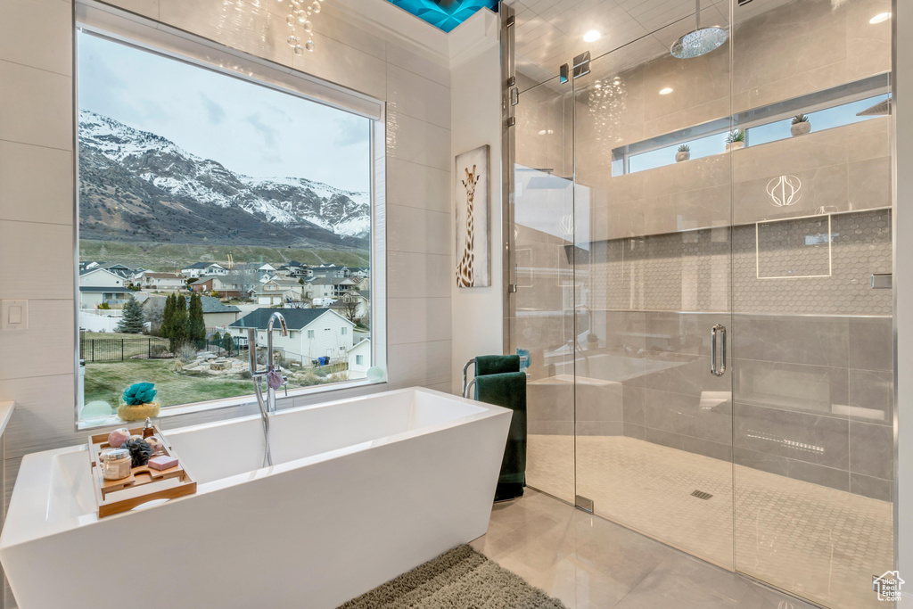 Bathroom featuring tile floors, tile walls, a wealth of natural light, and a mountain view