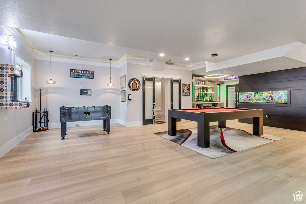 Game room with billiards, light wood-type flooring, bar area, and plenty of natural light