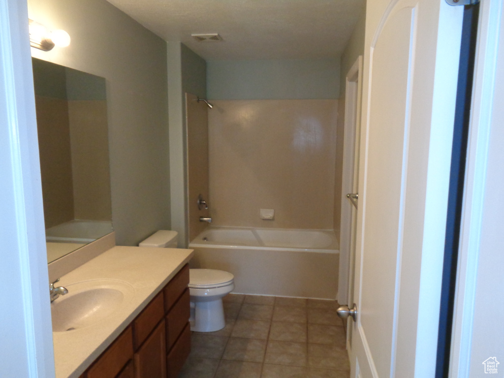 Full bathroom featuring  shower combination, toilet, vanity with extensive cabinet space, and tile floors