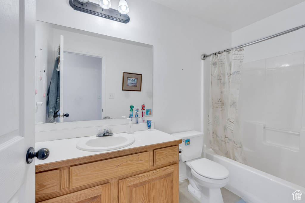 Full bathroom with shower / bath combination with curtain, large vanity, and toilet