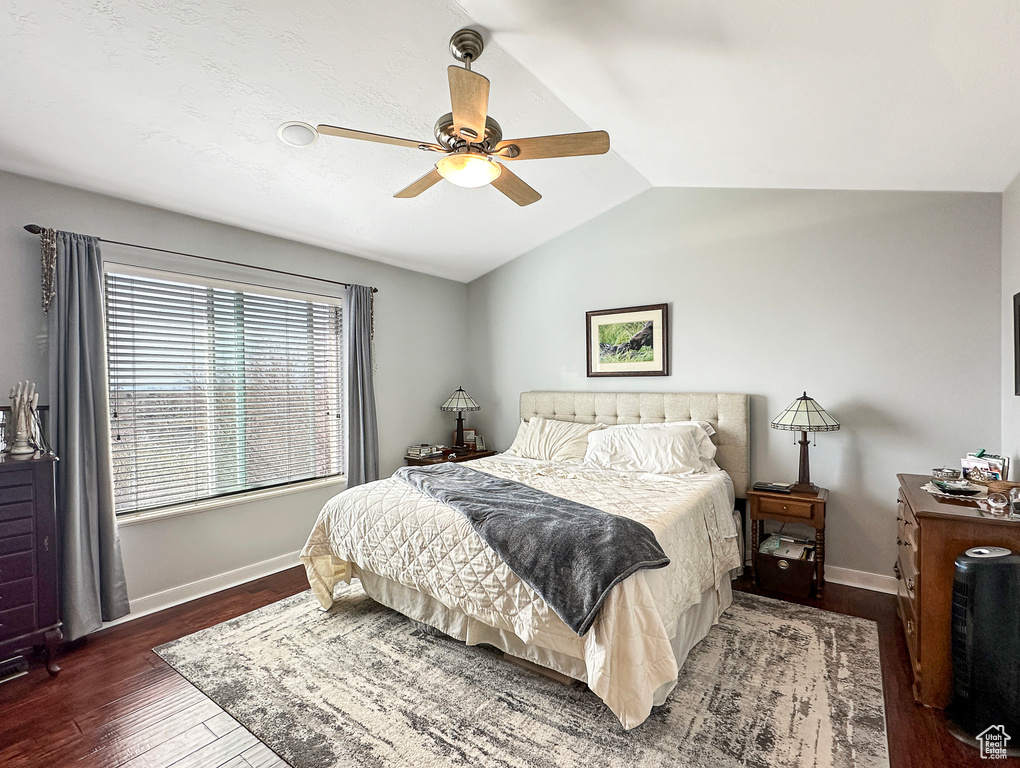 Bedroom with ceiling fan, lofted ceiling, and dark hardwood / wood-style floors
