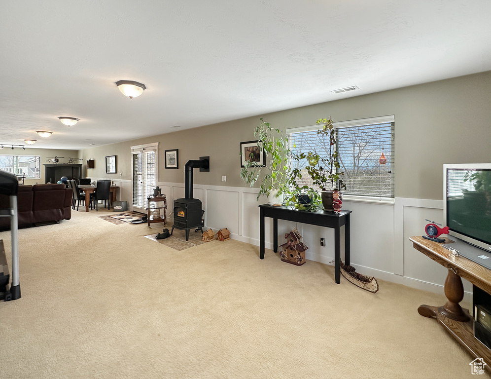Office area featuring light colored carpet and a wood stove