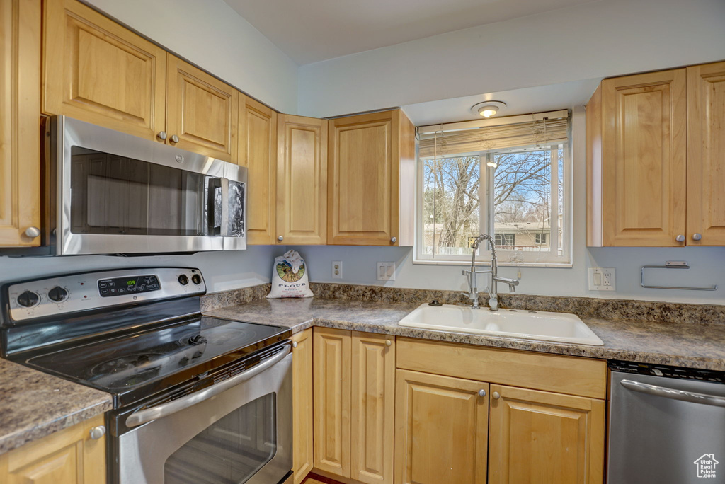 Kitchen featuring sink, light brown cabinets, and stainless steel appliances