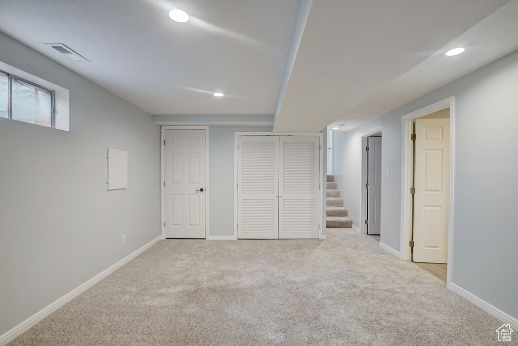 Basement featuring light colored carpet