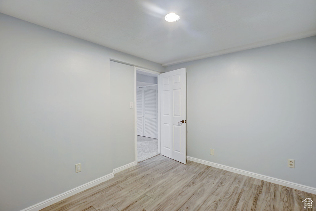 Empty room with light hardwood / wood-style flooring