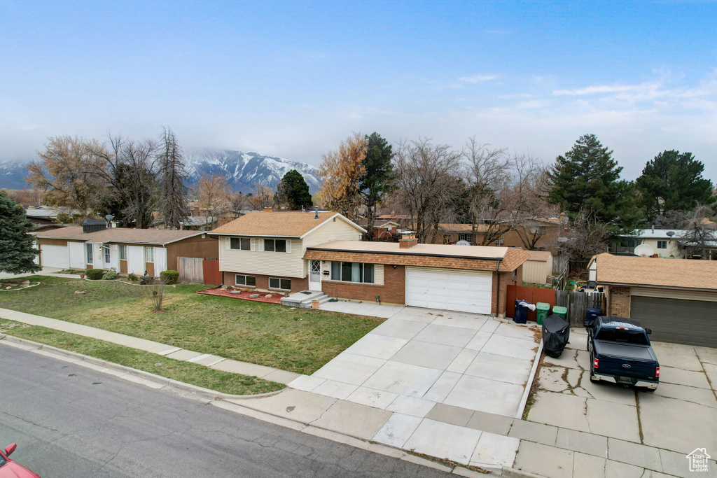Tri-level home with a mountain view and a front lawn