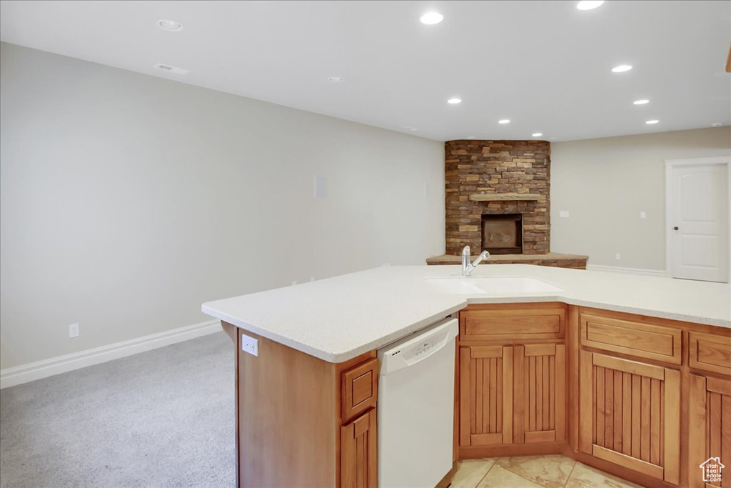 Kitchen featuring a stone fireplace, sink, light colored carpet, and dishwasher