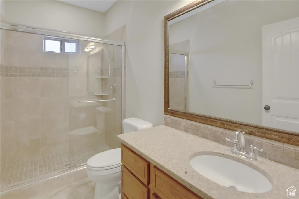 Bathroom with vanity, tile flooring, tasteful backsplash, an enclosed shower, and toilet