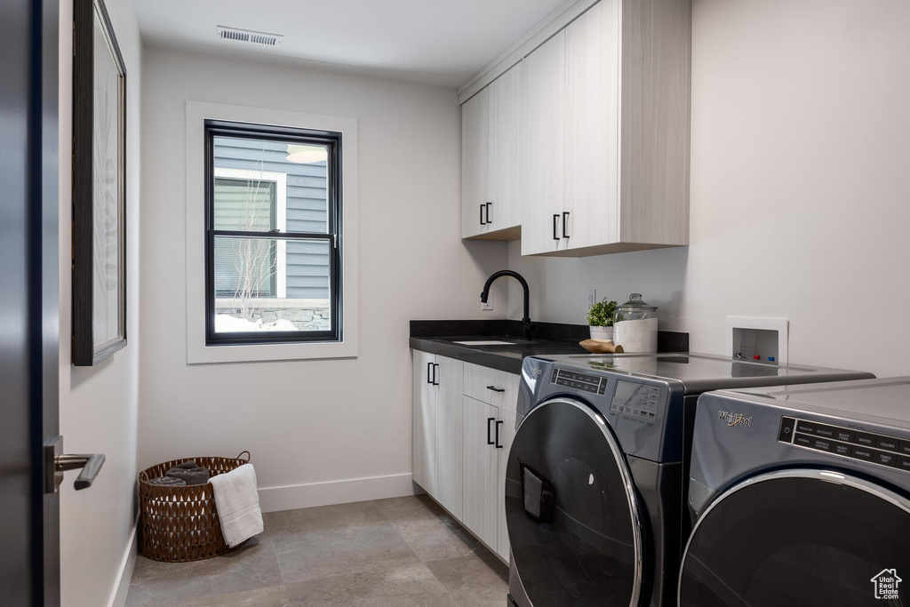 Washroom featuring independent washer and dryer, light tile flooring, washer hookup, sink, and cabinets