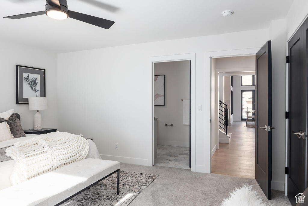 Bedroom with ceiling fan, ensuite bath, and light colored carpet