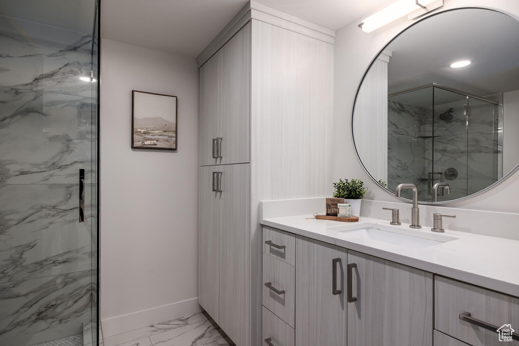 Bathroom with tile floors, walk in shower, and vanity