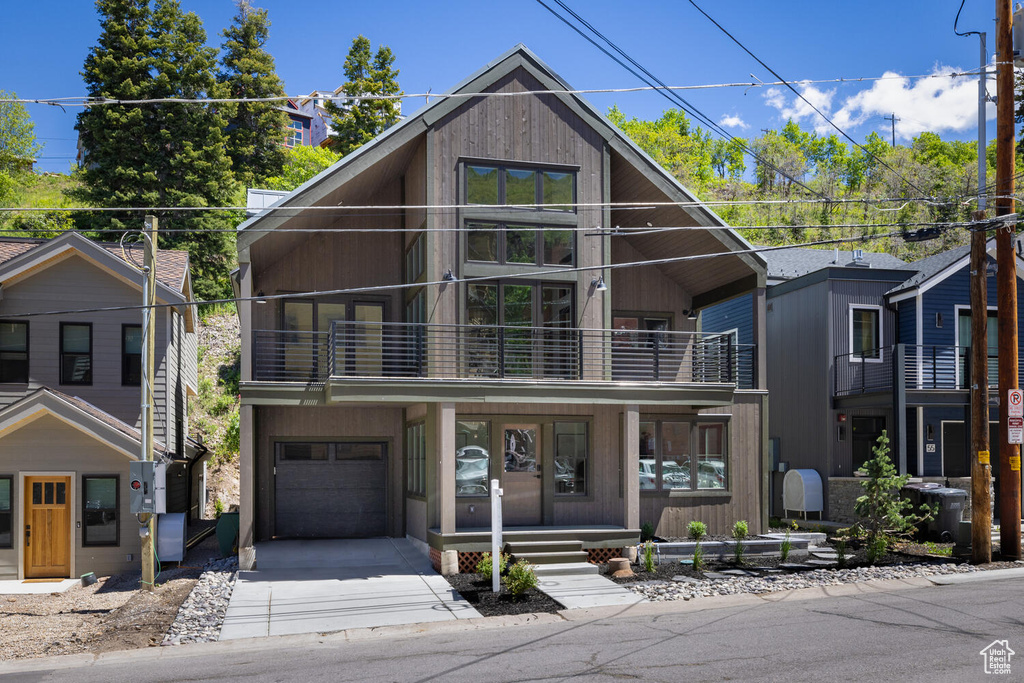 View of front of house with a garage and a balcony