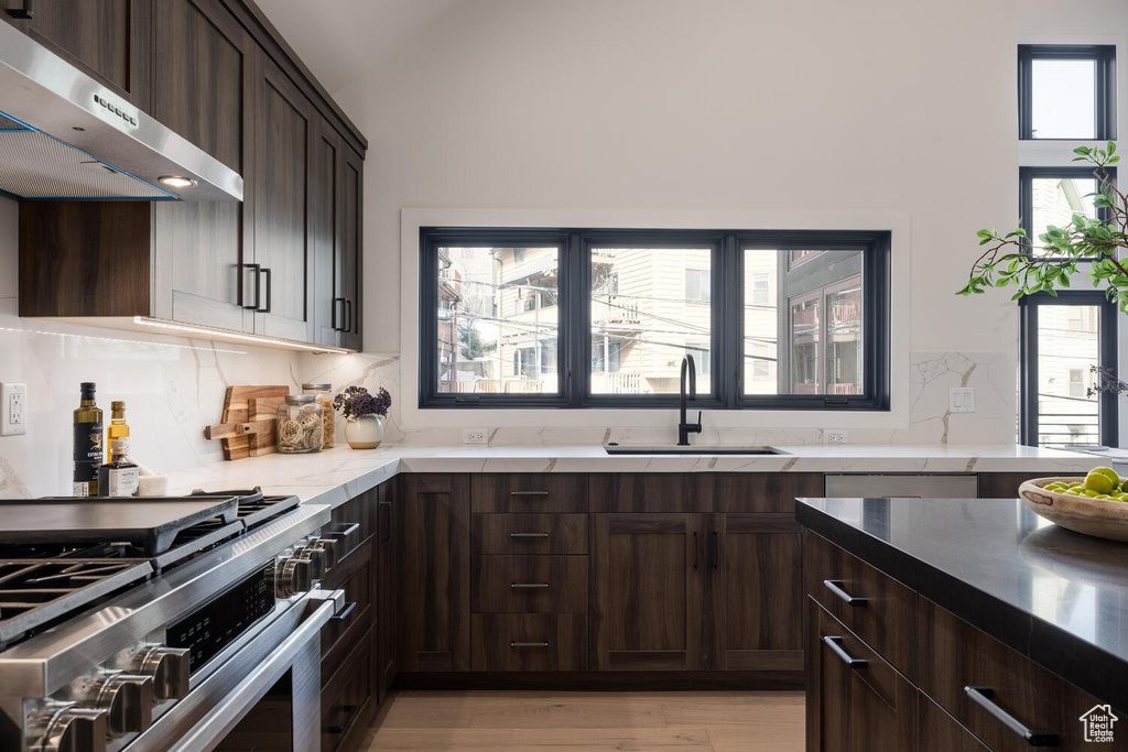 Kitchen featuring high end stove, sink, a wealth of natural light, and light hardwood / wood-style flooring