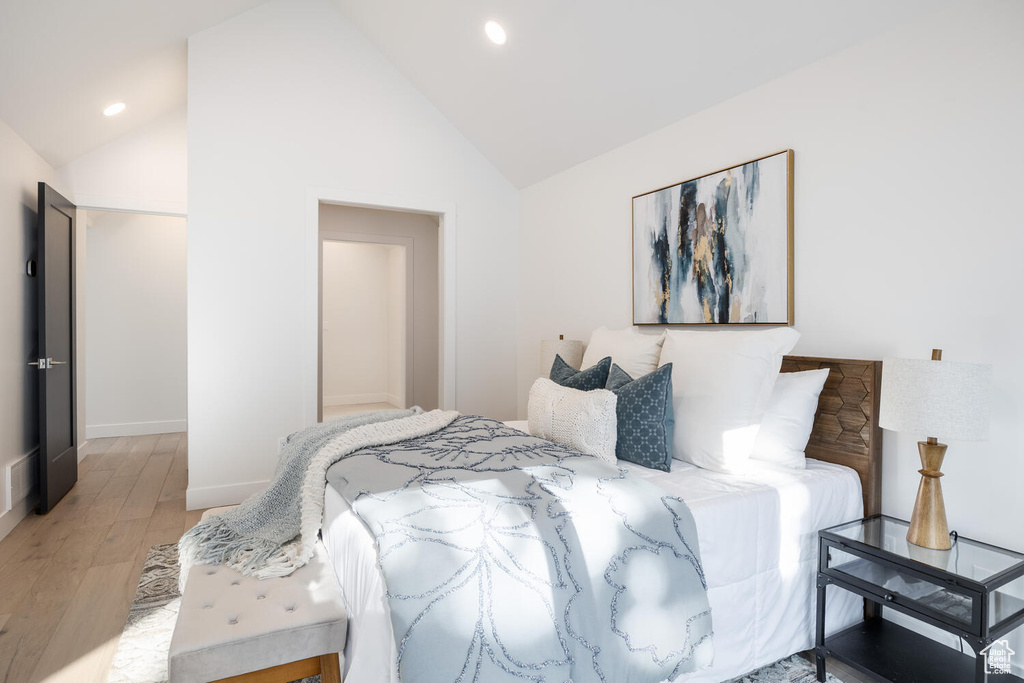 Bedroom featuring high vaulted ceiling and wood-type flooring