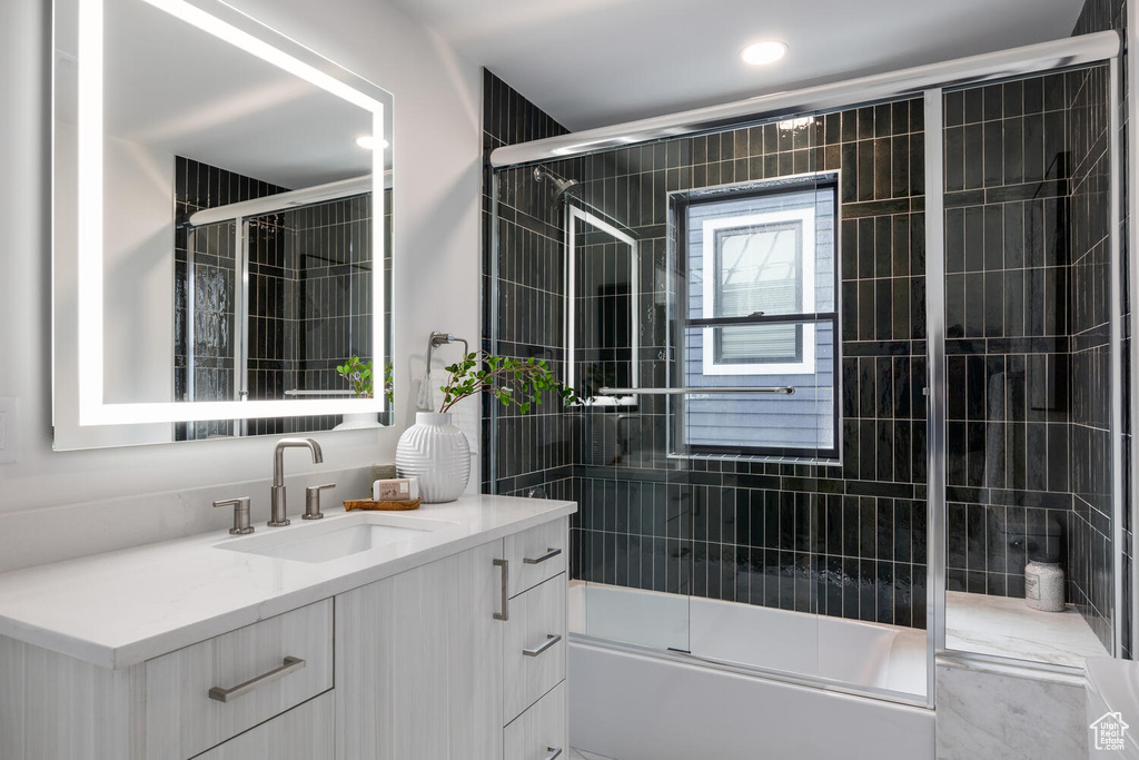 Bathroom with combined bath / shower with glass door and vanity