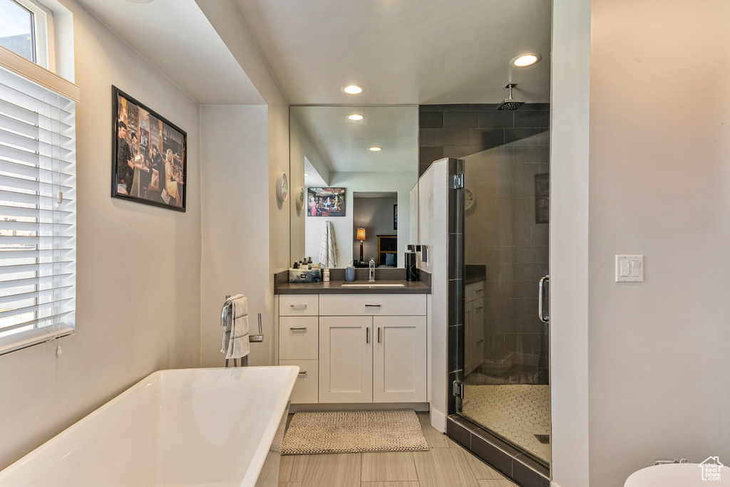 Bathroom featuring vanity, tile flooring, independent shower and bath, and a wealth of natural light