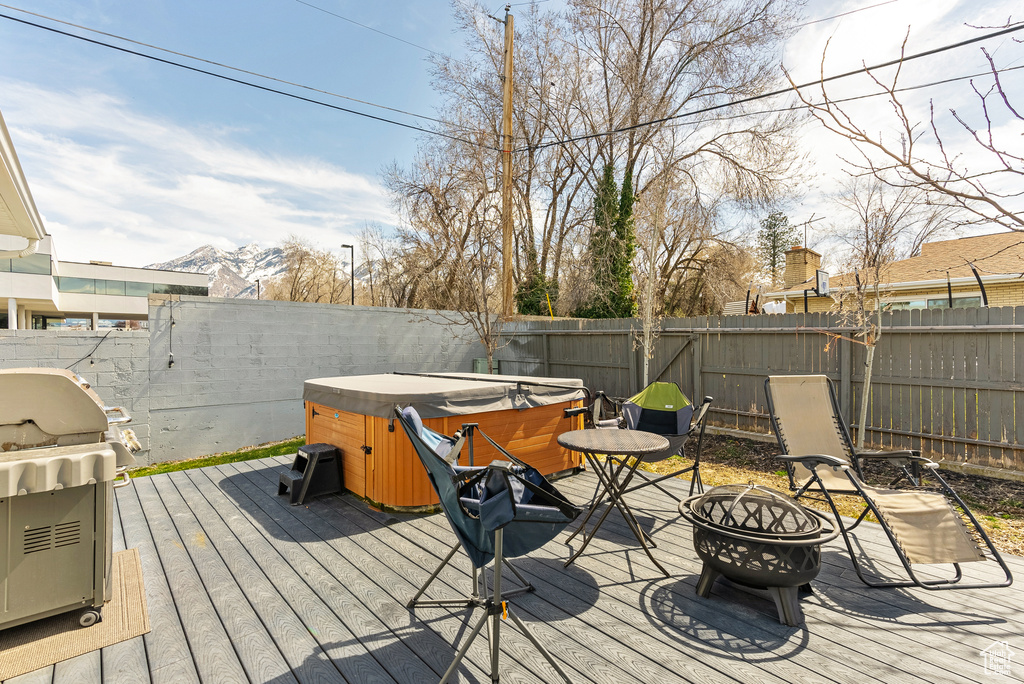 Deck featuring area for grilling, a hot tub, and a fire pit