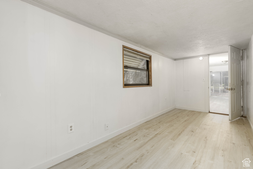 Unfurnished room with light wood-type flooring and a textured ceiling