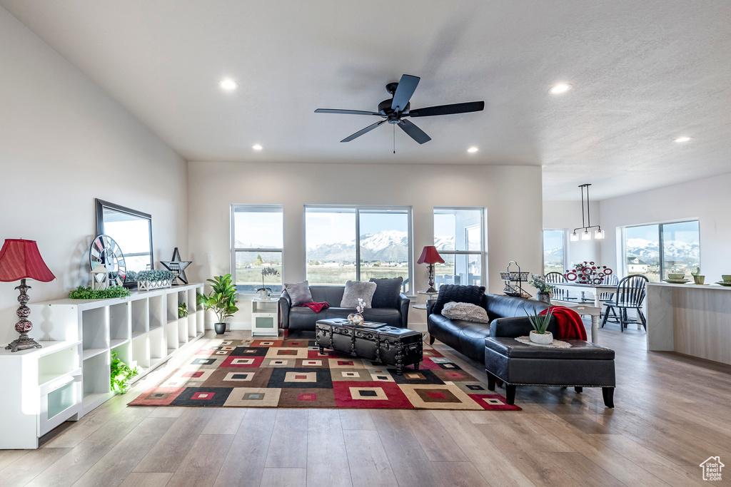 Living room featuring a healthy amount of sunlight, light hardwood / wood-style flooring, and ceiling fan