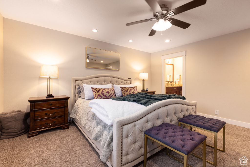 Carpeted bedroom featuring ensuite bath and ceiling fan