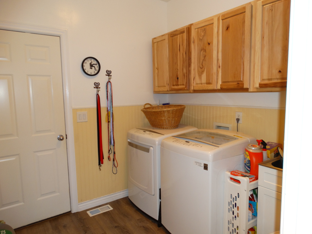 Laundry room featuring washing machine and dryer, cabinets, dark wood-type flooring, and washer hookup