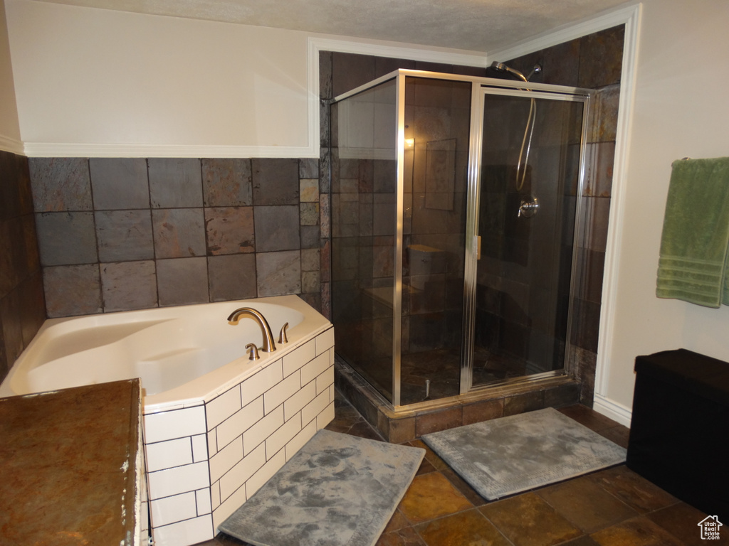 Bathroom with shower with separate bathtub and tile flooring