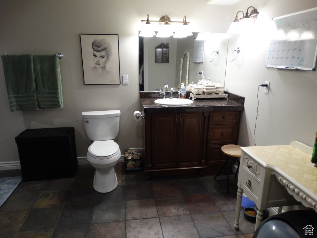 Bathroom with tile flooring, vanity, and toilet