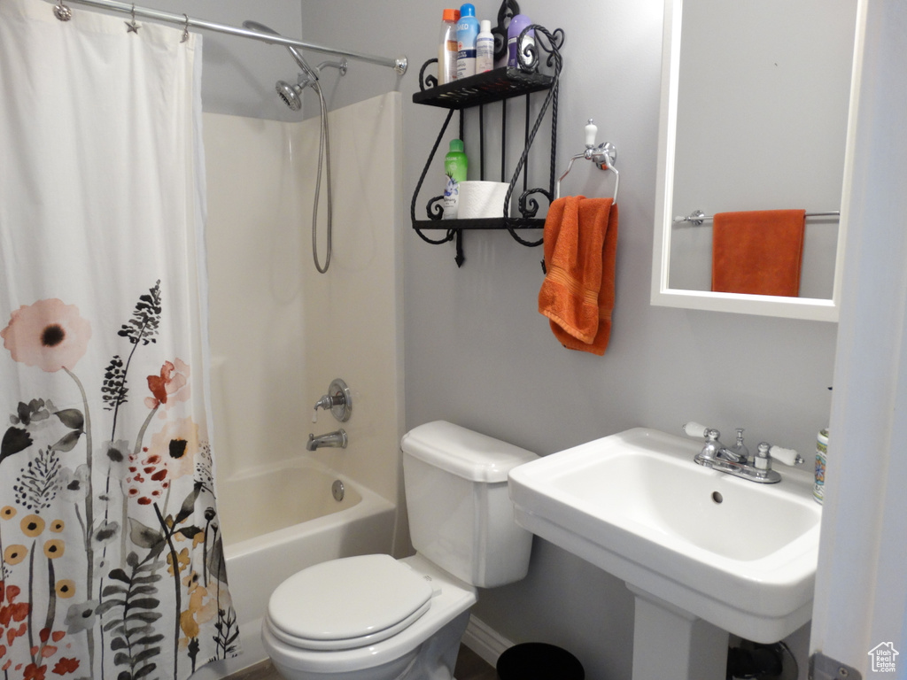 Full bathroom with sink, shower / bath combo, and toilet