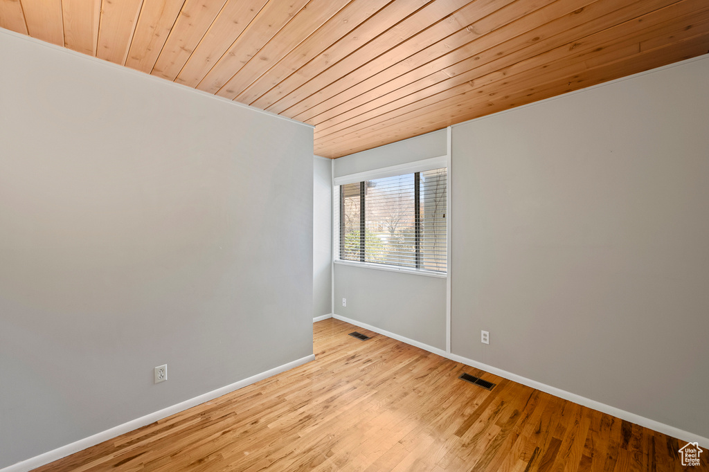 Unfurnished room featuring wood ceiling and light hardwood / wood-style flooring
