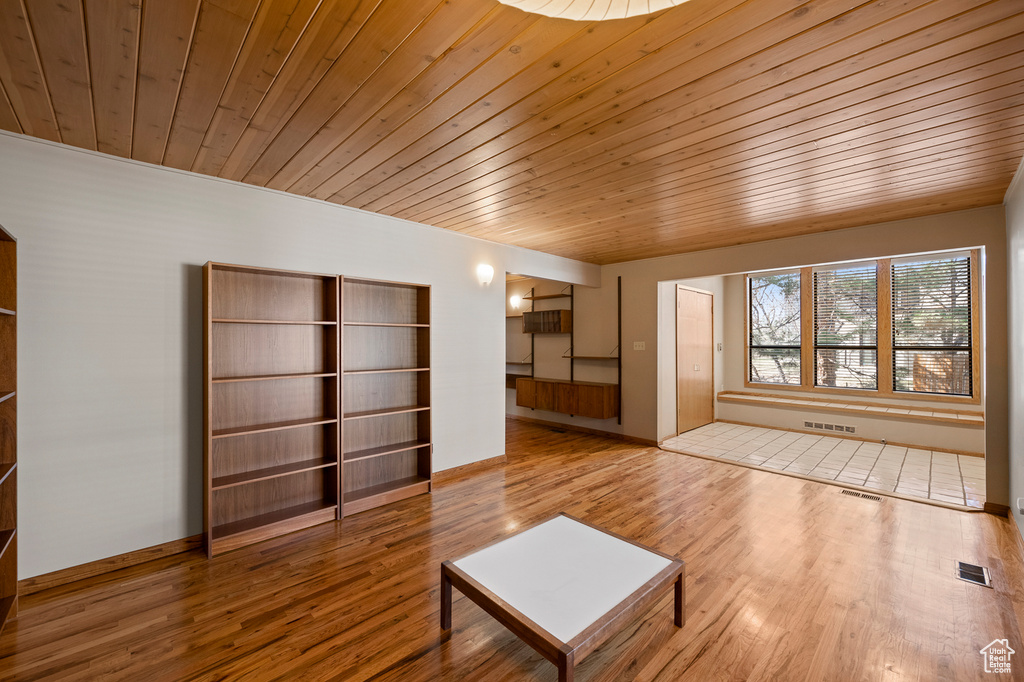 Unfurnished room featuring wood ceiling and light hardwood / wood-style flooring